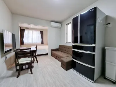 a small living room with a table and a couch at Lien \u897f\u65b0\u5bbf in Tokyo