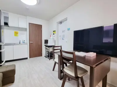 a office with a desk and a large screen tv at Lien \u897f\u65b0\u5bbf in Tokyo