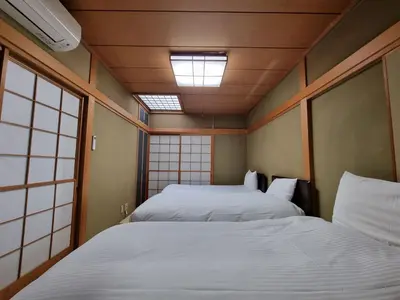 a small room with two beds and a skylight at PRISM COURT \u7dbe\u702c in Tokyo