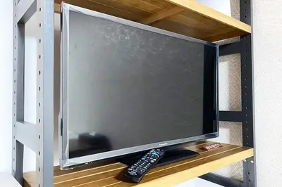 a flat screen tv with a remote control on a shelf at Mr Kintaro Hotel Asakusa South in Tokyo