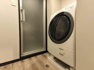 a washer and dryer in a room with a door at yksi SAUNA & STAY in Tokyo
