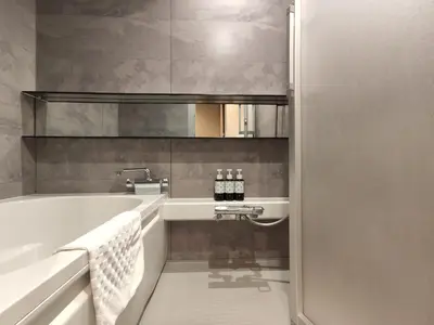 a bathroom with a bath tub and a sink at yksi SAUNA & STAY in Tokyo