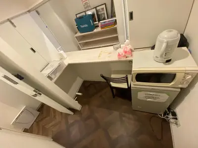 a kitchen with a microwave and a table with a counter at 54Journey \u6771\u4eac\u8d64\u5742\u30db\u30b9\u30c6\u30eb in Tokyo