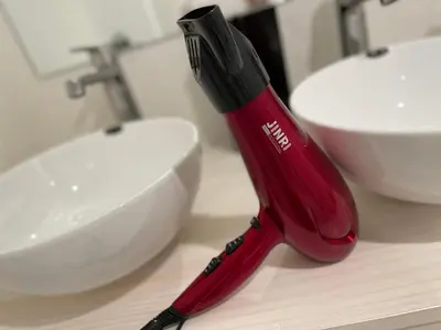 a red toothbrush sitting on a counter next to a sink at 54Journey \u6771\u4eac\u8d64\u5742\u30db\u30b9\u30c6\u30eb in Tokyo