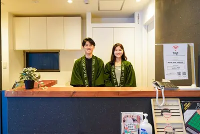 a man and a woman standing behind a counter at COB HOTEL Asakusa in Tokyo
