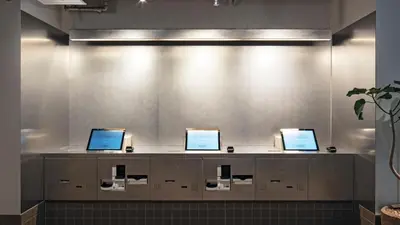 a waiting room with three computers on a counter at all day place shibuya in Tokyo