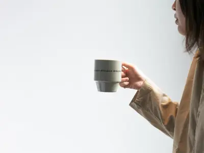 a woman holding a cup of coffee at all day place shibuya in Tokyo