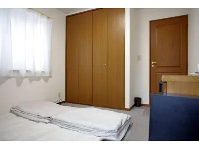 a bedroom with a bed and a wooden cabinet at NYOZE House - Vacation STAY 84305v in Tokyo