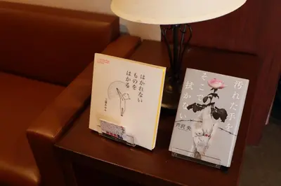 two books sitting on a table next to a lamp at BOOK HOTEL \u795e\u4fdd\u753a in Tokyo