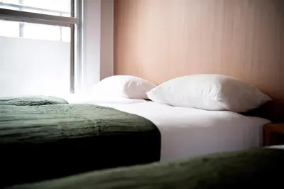 a bedroom with two beds with pillows and a window at renovated in June 2025 apartment 3mins walk to station 1stop to Shinjuku 3stop to Shibuya in Tokyo