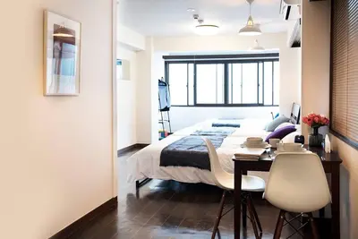 a bedroom with a bed and a table and chairs at ③2station to Shinjuku. 3 double beds. Specious 45㎡ in Tokyo