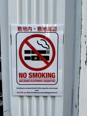 a no smoking sign is posted on a wall at ③2station to Shinjuku. 3 double beds. Specious 45㎡ in Tokyo