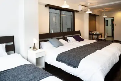 a bedroom with two large beds and a table at ③2station to Shinjuku. 3 double beds. Specious 45㎡ in Tokyo