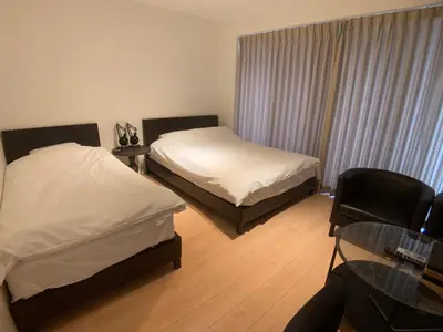 a hotel room with two beds and a glass table at SALON\u6e0b\u8c374A in Tokyo