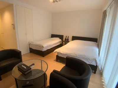a room with two beds and a chair and a table at SALON\u6e0b\u8c374A in Tokyo