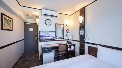 a hotel room with a desk and a bed at Toyoko Inn Tokyo Otemachi in Tokyo