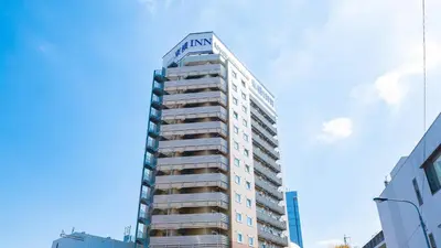 a tall building with a sign on top of it at Toyoko Inn Tokyo Keihin Tohoku sen Oji eki Kita guchi in Tokyo