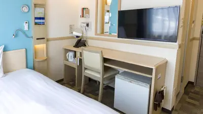 a room with a desk with a television and a bed at Toyoko Inn Tokyo Shinjuku gyoemmae eki 3 ban Deguchi in Tokyo