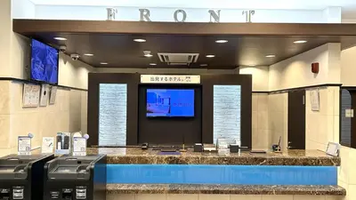 a hotel lobby with a television and a large counter at Toyoko Inn Omori in Tokyo