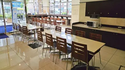 a dining room with tables and chairs in a cafeteria at Toyoko Inn Omori in Tokyo