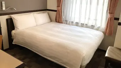 a bed in a room with a window at Toyoko Inn Tokyo Shinagawa Hatanodai eki Minami guchi in Tokyo