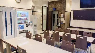 a classroom with tables and chairs and a refrigerator at Toyoko Inn Tokyo Shinagawa Hatanodai eki Minami guchi in Tokyo