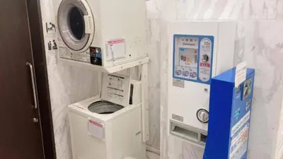 a small bathroom with a washing machine and a washer at Toyoko Inn Tokyo Nihombashi Zeimusho Mae in Tokyo