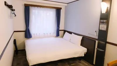a small bed in a small room with a window at Toyoko Inn Tokyo Nihombashi Zeimusho Mae in Tokyo