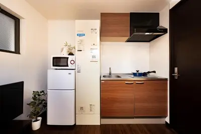 a small kitchen with a refrigerator and a microwave at Apartment Sun Bright - Vacation STAY 89260v in Tokyo
