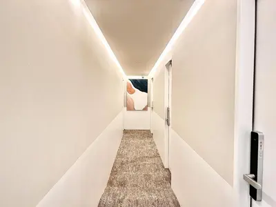 a corridor of a hallway with white walls and a long aisle at \u4e1c\u4eac\u4e2d\u5fc3\u4e0a\u91ce\u516c\u56ed\u65f6\u5c1a\u8bbe\u8ba1\u5e08\u623f\u95f4Ycoc \u4e0a\u91ce\u516c\u56ed3\u5206\u949f \u8f66\u7ad91\u5206\u949f \u8d85\u7ea7\u7e41\u534e \u514d\u8d39wifi \u6234\u68ee\u5439\u98ce in Tokyo