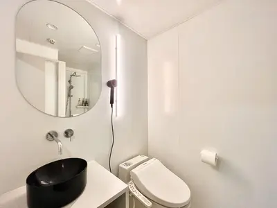 a white bathroom with a mirror and a toilet at \u4e1c\u4eac\u4e2d\u5fc3\u4e0a\u91ce\u516c\u56ed\u65f6\u5c1a\u8bbe\u8ba1\u5e08\u623f\u95f4Ycoc \u4e0a\u91ce\u516c\u56ed3\u5206\u949f \u8f66\u7ad91\u5206\u949f \u8d85\u7ea7\u7e41\u534e \u514d\u8d39wifi \u6234\u68ee\u5439\u98ce in Tokyo