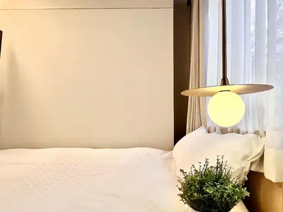 a bedroom with a bed and a lamp and a plant at \u4e1c\u4eac\u4e2d\u5fc3\u4e0a\u91ce\u516c\u56ed\u65f6\u5c1a\u8bbe\u8ba1\u5e08\u623f\u95f4Ycoc \u4e0a\u91ce\u516c\u56ed3\u5206\u949f \u8f66\u7ad91\u5206\u949f \u8d85\u7ea7\u7e41\u534e \u514d\u8d39wifi \u6234\u68ee\u5439\u98ce in Tokyo