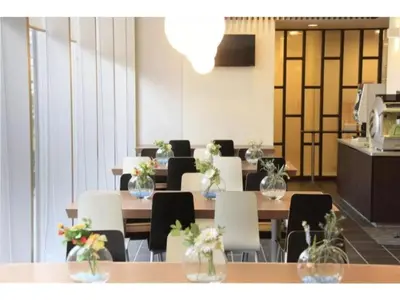 a dining room with tables and chairs with flowers on them at R&B Hotel Tokyo Toyocho - Vacation STAY 40490v in Tokyo