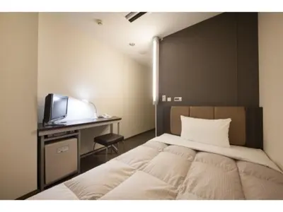 a bedroom with a bed and a desk with a television at R&B Hotel Otsuka Eki Kitaguchi - Vacation STAY 40485v in Tokyo