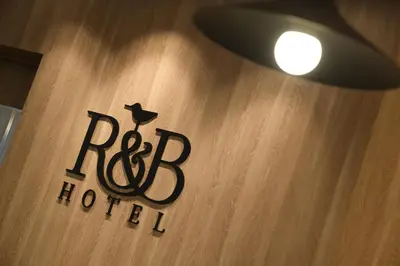 a sign for a hotel on a wooden wall at R&B Hotel Otsuka Eki Kitaguchi - Vacation STAY 40487v in Tokyo