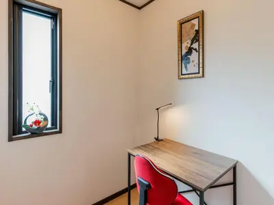 a room with a wooden table and a red chair at YADOYA Ryusenjicho in Tokyo