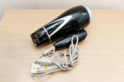a black and white hair dryer on a wooden table at The Felice Uguisudani - Vacation STAY 96221 in Tokyo