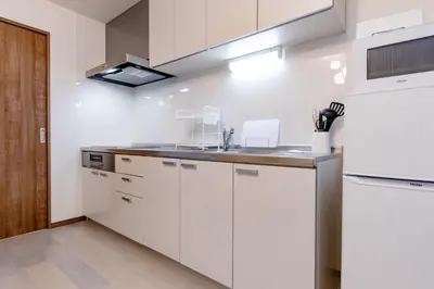 a white kitchen with a sink and a refrigerator at The Felice Uguisudani - Vacation STAY 96241 in Tokyo