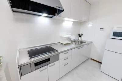 a white kitchen with a sink and a refrigerator at The Felice Uguisudani - Vacation STAY 96242 in Tokyo