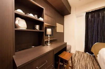 a hotel room with a bed and a desk with a television at Centurion Hotel Grand Akasakamitsuke Station in Tokyo