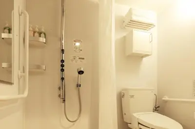 a white bathroom with a shower and a toilet at Centurion Hotel Grand Akasakamitsuke Station in Tokyo