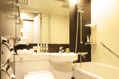 a bathroom with a sink and a toilet and a tub at Centurion Hotel Grand Akasakamitsuke Station in Tokyo