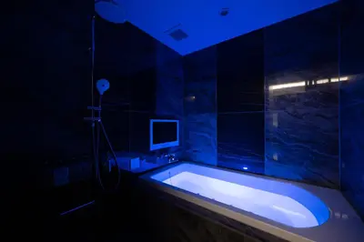 a bathroom with a bath tub with a blue lighting at HOTEL VARKIN Ikebukuro Nishiguchi in Tokyo