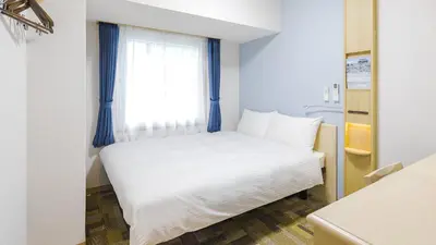 a white bed in a room with a window at Toyoko Inn Tokyo Ikebukuro Kita guchi No 2 in Tokyo
