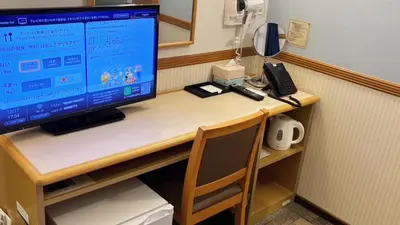 a desk with a computer monitor and a phone on it at Toyoko Inn Tokyo eki Shin ohashi Mae in Tokyo