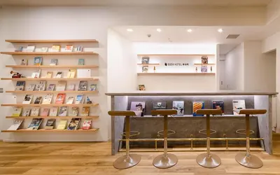 a bar with three stools in a room with books at No, 2 Taniji Building - Vacation STAY 91347v in Tokyo