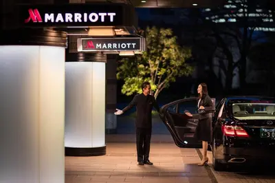 a man and a woman standing in front of a car at Tokyo Marriott Hotel in Tokyo