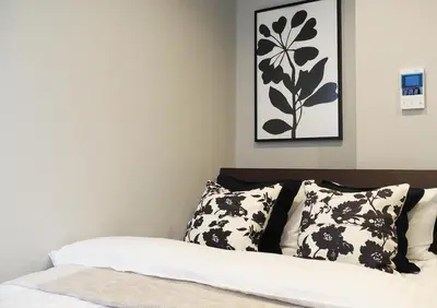 a bedroom with a bed with black and white pillows at LANG HOTEL Kameido#Near Akihabara#\u30c1\u30a7\u30c3\u30af\u30a2\u30a6\u30c8\u306e\u307f\u6e05\u6383\u3042\u308a in Tokyo