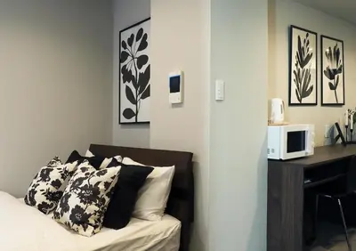 a bedroom with a bed and a desk with a microwave at LANG HOTEL Kameido#Near Akihabara#\u30c1\u30a7\u30c3\u30af\u30a2\u30a6\u30c8\u306e\u307f\u6e05\u6383\u3042\u308a in Tokyo
