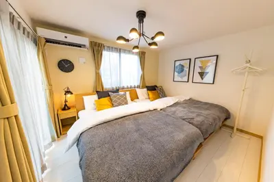 a bedroom with a large bed with yellow pillows at Y's HOTEL KAMEARI in Tokyo